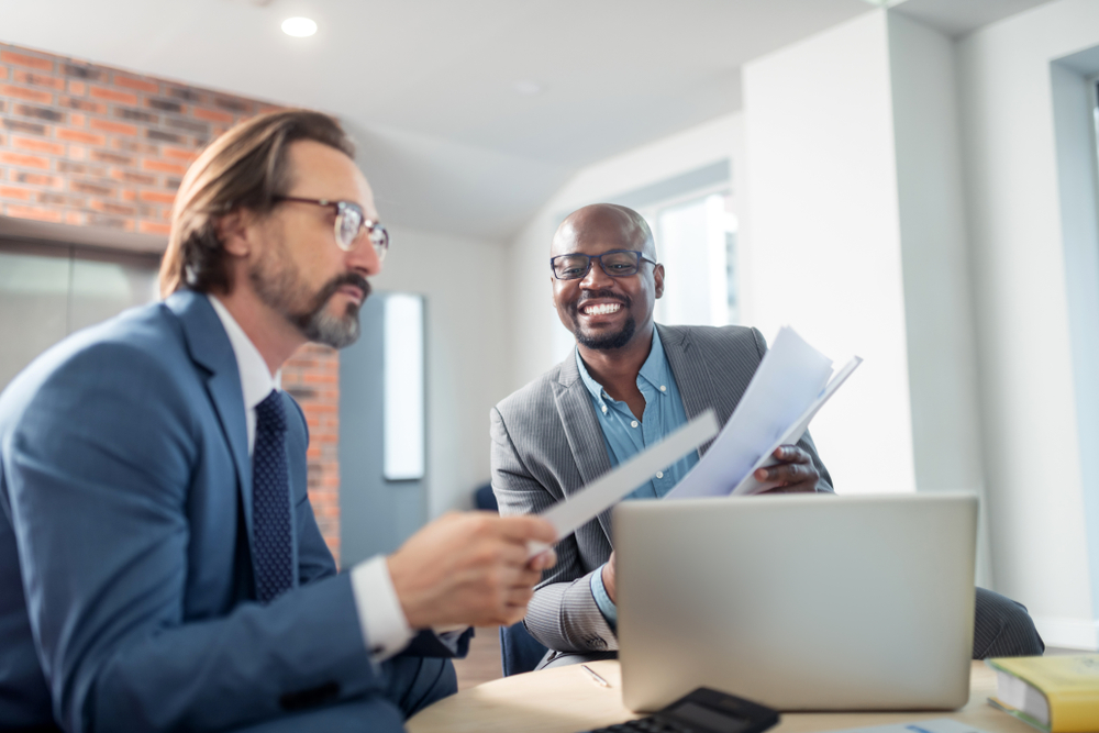 Cooperating,With,Colleague.,Dark-skinned,Businessman,Smiling,While,Cooperating,With,Professional