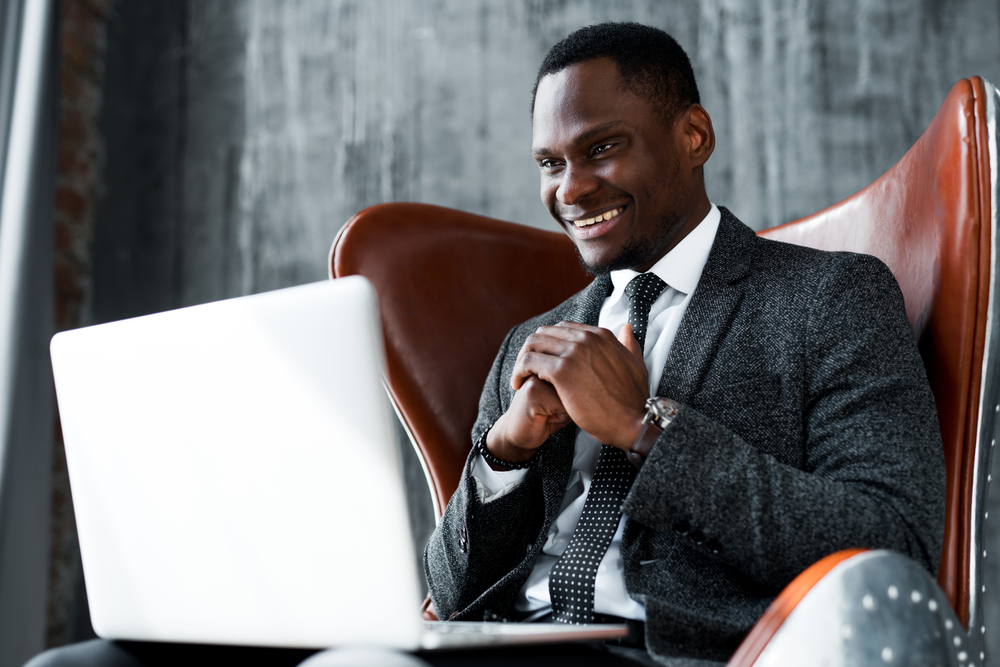 Smiling,Dark-skinned,Businessman,In,A,Suit,Sitting,In,An,Office